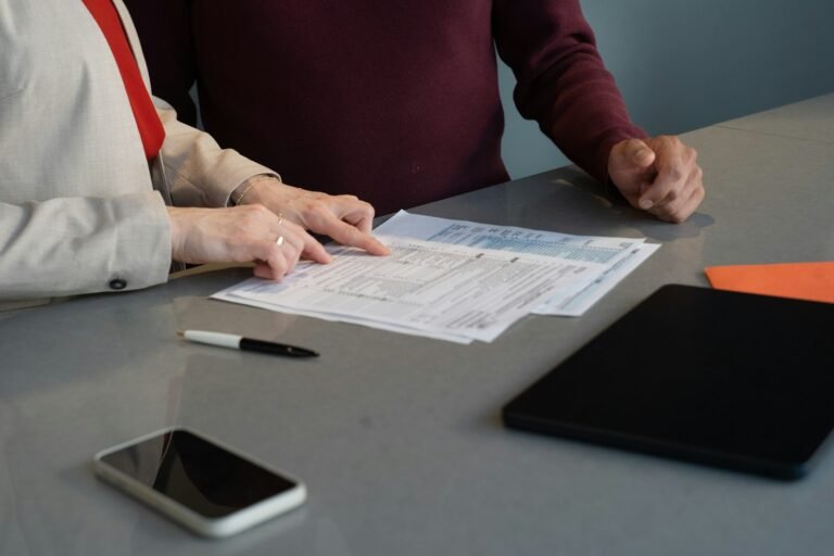 Dos personas revisando un formulario sobre una mesa